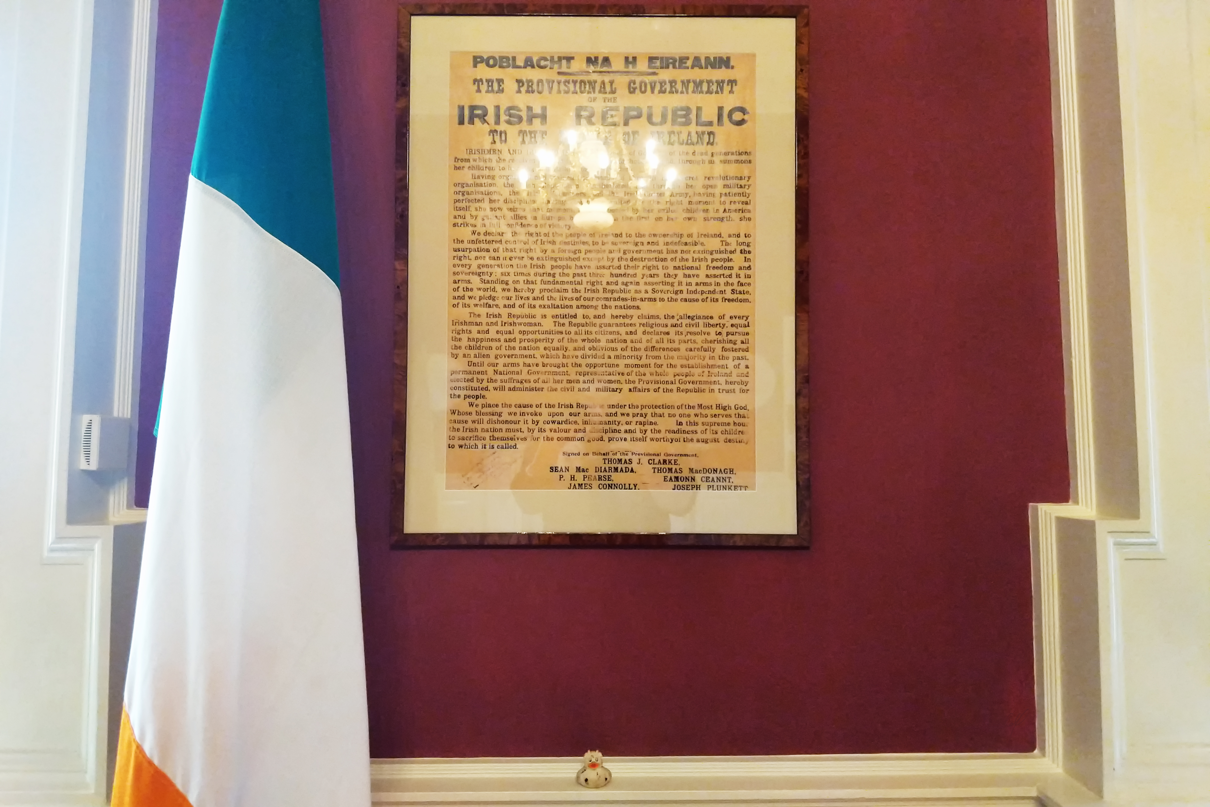 A photo of Bella the rubber duck in front of the Proclamation of the Irish Republic in The James Connolly room at Dublin Castle, Ireland