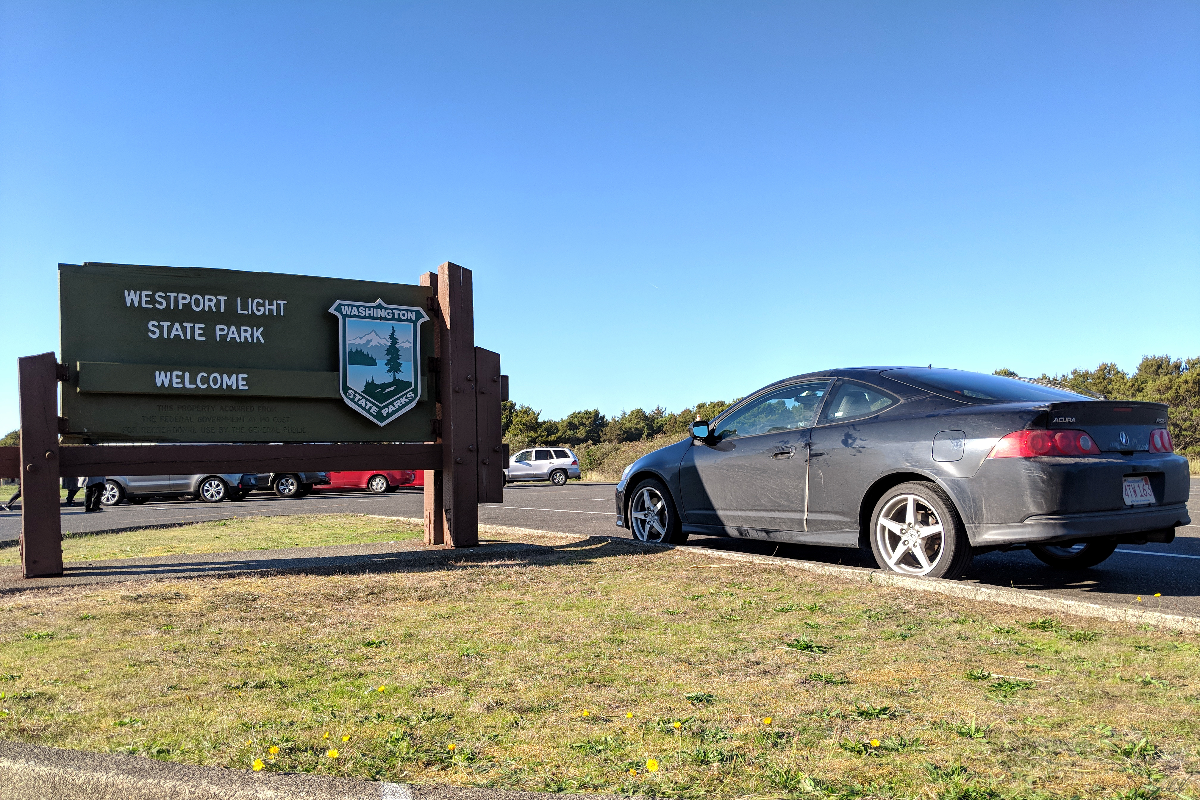 A photo of Bella the rubber duck on my Acura RSX next to the sign for Westport Light State Park, Washington